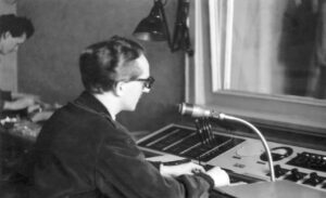 Mann mit Brille vor Mikrofon und historischem Mischpult